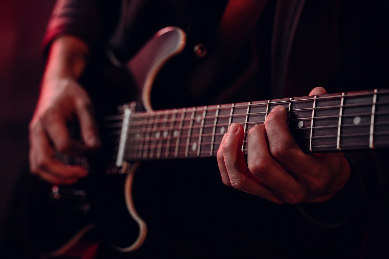 Manos de músico en guitarra durante el ensayo